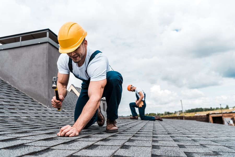Roofer checking asphalt shingles during a repair